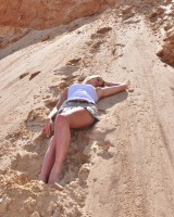 девушка в мини-юбке на песке
