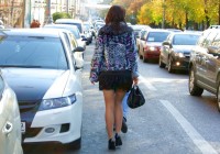 девушка в чулках и мини юбке идет по улице
