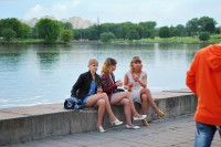 три девушки сидят на набережной